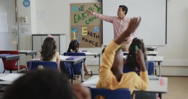 Glad Mångsidig Skolbarn Vid Skrivbord Höja Händerna Och Manlig Lärare — Stockvideo