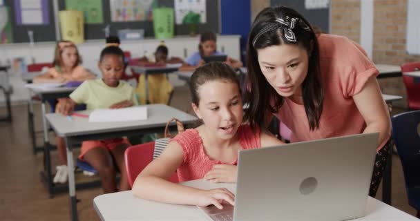Szczęśliwa Zróżnicowana Nauczycielka Uczy Uczennice Korzystające Laptopa Klasie Szkole Podstawowej — Wideo stockowe