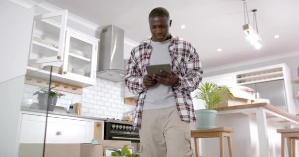 非裔美国人坐在厨房的楼梯上 在家里用平板电脑 动作缓慢 生活方式 宠物和家庭生活 — 图库视频影像