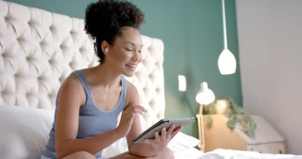 Mujer Birracial Feliz Con Auriculares Sentados Cama Uso Tableta Dormitorio — Vídeo de stock