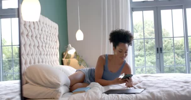 Glad Biracial Kvinna Liggande Sängen Och Talar Smartphone Sovrum Slow — Stockvideo