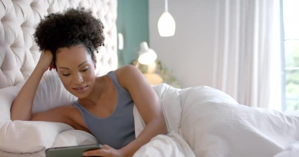 Heureuse Femme Biraciale Couchée Lit Utilisant Smartphone Dans Chambre Ralenti — Video