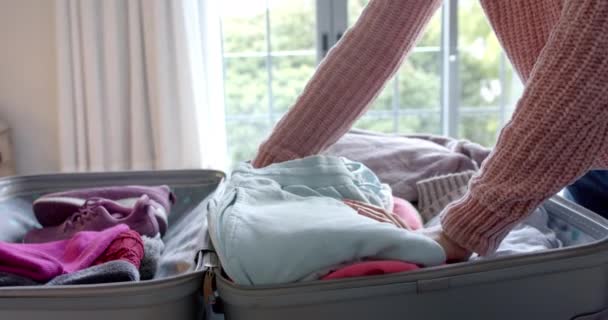 Handen Van Biracial Vrouw Verpakking Koffer Zonnige Slaapkamer Slow Motion — Stockvideo