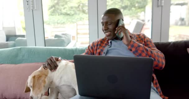 Homem Americano Africano Feliz Smartphone Usando Laptop Casa Com Seu — Vídeo de Stock