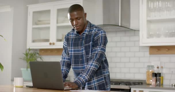Afro Americano Usando Laptop Falando Smartphone Cozinha Casa Câmera Lenta — Vídeo de Stock