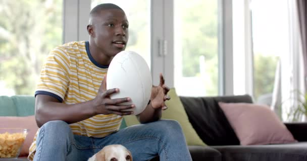 Glad Afrikansk Amerikansk Man Soffan Tittar Rugby Match Hemma Med — Stockvideo