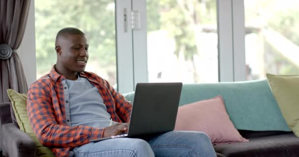 Szczęśliwy Afrykański Amerykanin Siedzący Kanapie Laptopem Domu Zwolniony Ruch Styl — Wideo stockowe
