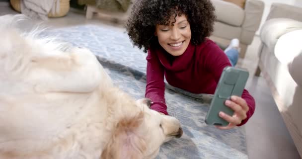 Счастливая Двуличная Женщина Фотографируется Золотистой Собакой Ретривером Используя Смартфон Дома — стоковое видео