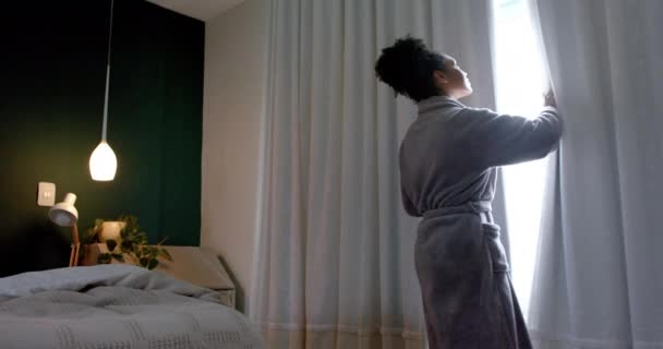 Parte Posterior Mujer Biracial Albornoz Cortinas Apertura Dormitorio Cámara Lenta — Vídeo de stock