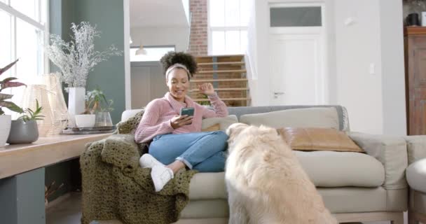 Ευτυχισμένη Biracial Γυναίκα Χάιδεμα Χρυσό Σκύλο Retriever Και Χρήση Smartphone — Αρχείο Βίντεο