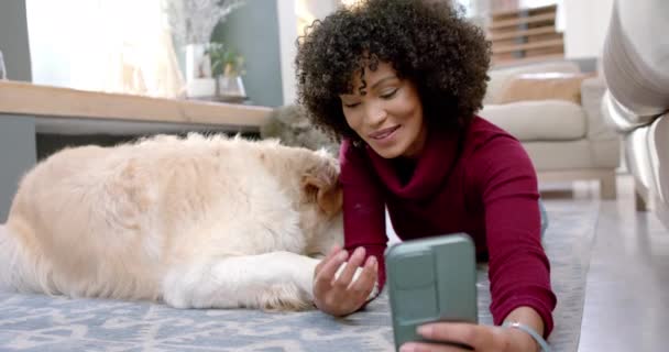 自宅でスマートフォンを使用してゴールデンレトリーバー犬とハッピーな女性 スローモーション ライフスタイル コミュニケーション 家庭生活 — ストック動画