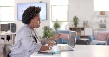 Afro-amerikan iş kadını yemek yiyor ve laptopunu ofiste kullanıyor, ağır çekimde. Günlük ofis, iş, iletişim, yemek ve iş, değiştirilmemiş.