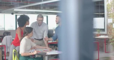 Muhtelif mimarlardan oluşan bir ekip ofiste bir planı tartışıyor. İş, ofis ve mühendislik teknolojisi kavramı