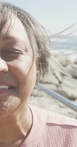 Pystysuora Video Muotokuva Vanhempi Biracial Nainen Kävelykatu Meren Rannalla Hidastettuna — kuvapankkivideo