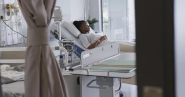 Afrika kökenli Amerikalı kadın hasta hastane odasında ağır çekimde yatıyor. Sağlık hizmetleri, sağlık ve ilaç, değiştirilmemiş..