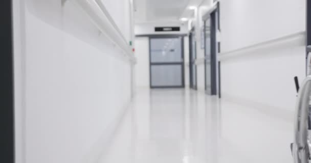 Αφροαμερικανή Γιατρός Που Τρέχει Αναπηρικό Καροτσάκι Στο Διάδρομο Του Νοσοκομείου — Αρχείο Βίντεο