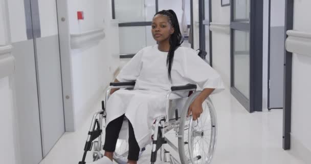Paziente Afroamericana Sulla Sedia Rotelle Nel Corridoio Dell Ospedale Rallentatore — Video Stock