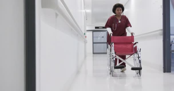 Medica Afroamericana Che Corre Con Sedia Rotelle Nel Corridoio Dell — Video Stock