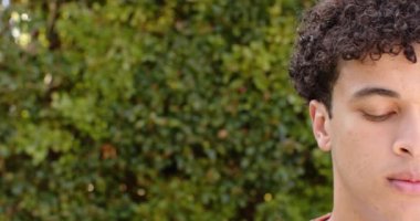 Açık havada çitin önünde gülümseyen melez bir adam, ağır çekim, kopyalama alanı. Erkeklik, doğa, bitki ve açık hava, değiştirilmemiş.