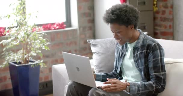 Heureux Homme Afro Américain Assis Sur Canapé Utilisant Ordinateur Portable — Video