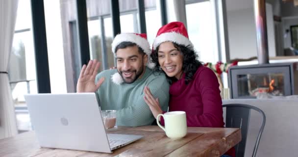 Szczęśliwa Para Dwurasowa Kapeluszach Świętego Mikołaja Używająca Laptopa Rozmów Wideo — Wideo stockowe