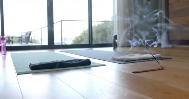 关闭瑜伽垫 水瓶和香在地板上 慢动作 室内设计 瑜伽和家庭生活 — 图库视频影像