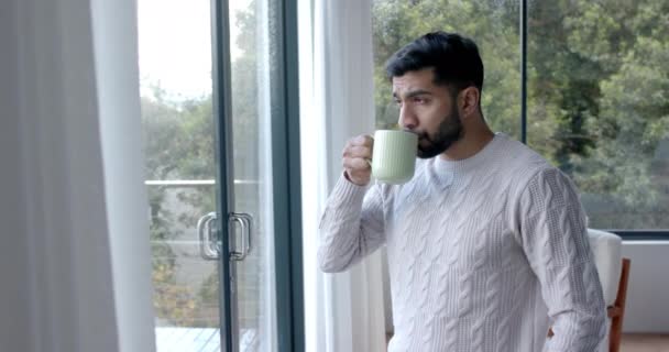 Homme Biracial Réfléchi Buvant Café Regardant Par Fenêtre Maison Ralenti — Video