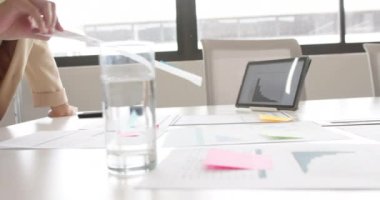 Toplantı odasında notlar ve tablet kullanan tesettürlü çift ırklı iş kadınının elleri, ağır çekim. Günlük ofis, iş, iletişim ve iş, değiştirilmemiş.