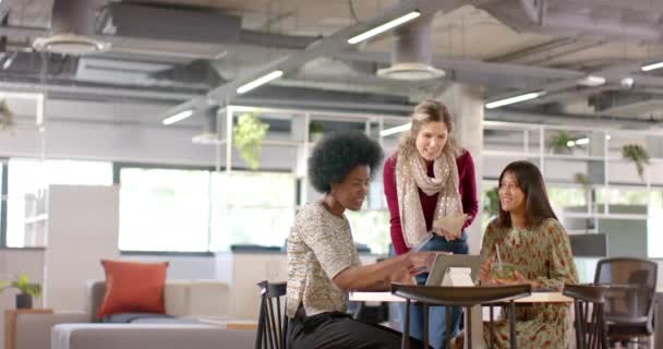 多様な女性クリエイティブな同僚がタブレットを使用して話し合い オフィスで昼食を食べ ゆっくりとした動きをします カジュアル オフィス ビジネス チームワーク コミュニケーションおよび仕事 変わらない — ストック動画