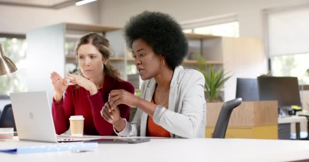 オフィスでラップトップを使用して議論中の多様な女性の創造的な同僚 スローモーション カジュアル オフィス ビジネス チームワーク コミュニケーションおよび仕事 変わらない — ストック動画