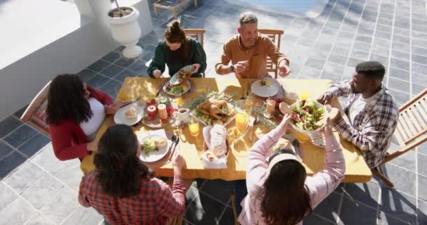日当たりの良い庭で感謝祭の食事に奉仕する多様な男性と女性の友人 愛国心 アメリカの文化と伝統 変わらない — ストック動画