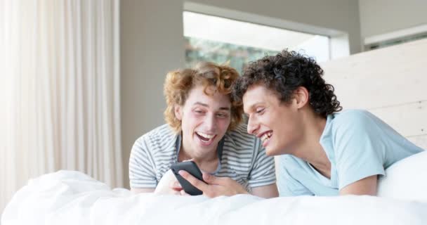Щаслива Різноманітна Гомосексуальна Пара Лежить Ліжку Використовує Смартфон Вдома Повільний — стокове відео