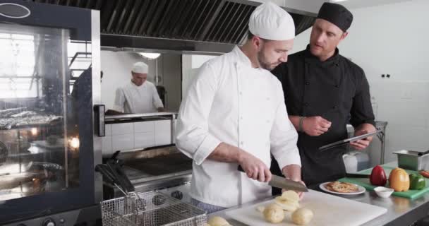 Cuoco Caucasico Focalizzato Che Istruisce Tirocinante Chef Maschio Con Tablet — Video Stock