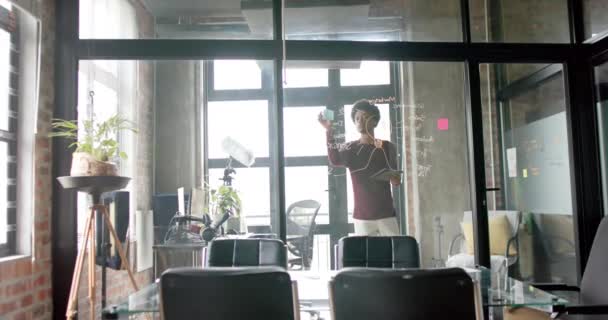 非裔美国商人使用平板电脑在办公室墙上书写 动作缓慢 复制空间 总公司 远程工作和临时业务 未加改动 — 图库视频影像