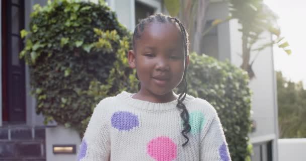 ハッピーアフリカ系アメリカ人の少女の肖像画は 日当たりの良い庭で微笑んで ゆっくりと動いています 子供時代 自由な時間 幸福とライフスタイル 変わらない — ストック動画