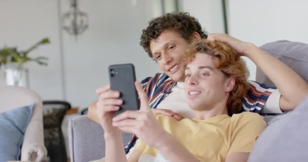 Heureux Divers Gay Mâle Couple Assis Canapé Utilisant Smartphone Maison — Video