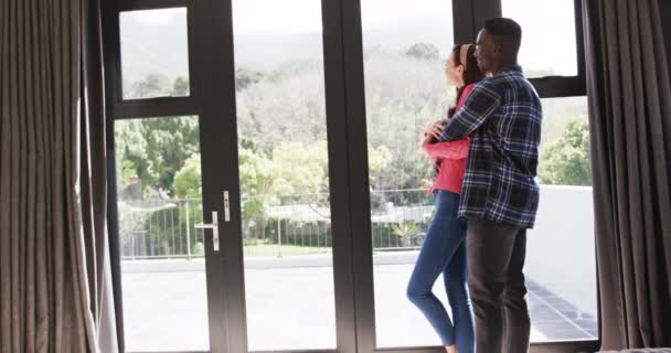 Heureux Couple Diversifié Regardant Par Fenêtre Souriant Embrassant Ralenti Espace — Video