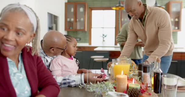 感謝祭の夕食 ゆっくりとした動きで食事を提供するハッピーなアフリカ系アメリカ人の世代の家族 感謝祭 お祝い トータルネス — ストック動画