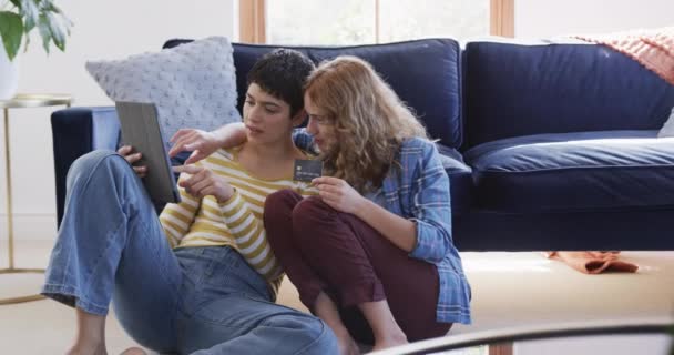 Szczęśliwa Biała Para Lesbijek Obejmująca Się Podłodze Używając Tabletu Karty — Wideo stockowe
