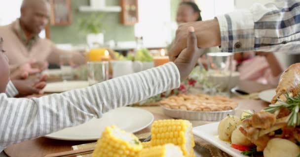 感謝祭の夕食で手を握っているハッピーアフリカ系アメリカ人の多世代家族 ゆっくりとした動き 感謝祭 お祝い トータルネス — ストック動画