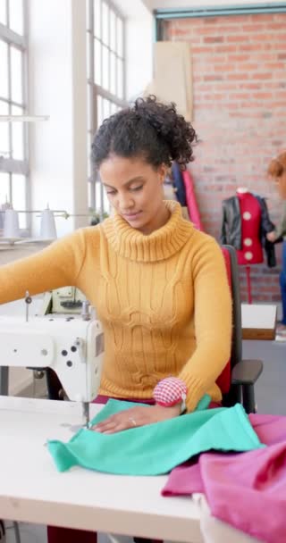 不同的女性时装设计师缝纫面料与缝纫机在工作室 慢动作 女性气质 服装和创意企业 — 图库视频影像
