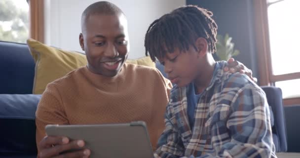 Χαρούμενος Αφρικάνος Πατέρας Και Γιος Κάθονται Στο Πάτωμα Και Χρησιμοποιούν — Αρχείο Βίντεο