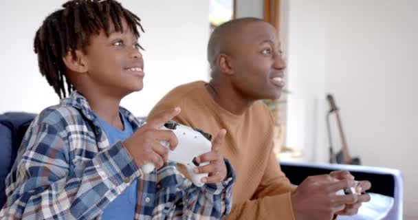 快乐的非洲裔美国父亲和儿子玩电子游戏 在家里鬼混 动作缓慢 生活方式 闲暇时间 家庭和家居生活 — 图库视频影像