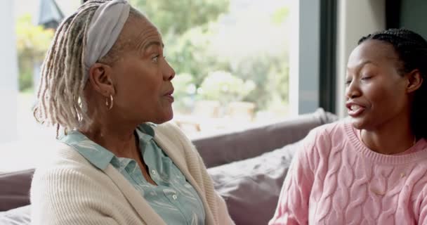 ハッピーアフリカ系アメリカ人のシニアマザーと娘がソファーで 抱きしめ ゆっくりとした動きをしています ホーム トータルネス 家庭生活とライフスタイル 変更されていない — ストック動画