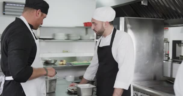 主力为高加索男性厨师 在厨房指导见习男性厨师 动作缓慢 餐馆和饮食业 未经改动 — 图库视频影像