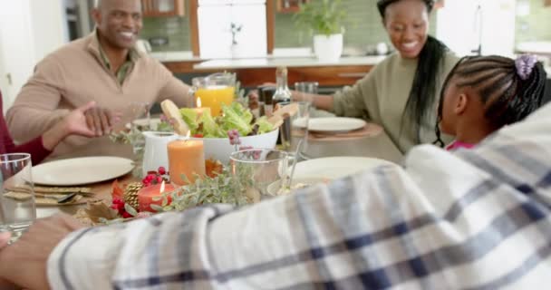 感謝祭の夕食で手を握っているハッピーアフリカ系アメリカ人の多世代家族 ゆっくりとした動き 感謝祭 お祝い トータルネス — ストック動画