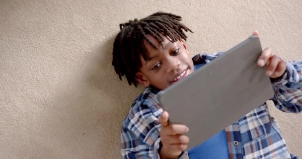 Menino Afro Americano Feliz Usando Tablet Deitado Chão Casa Câmera — Vídeo de Stock