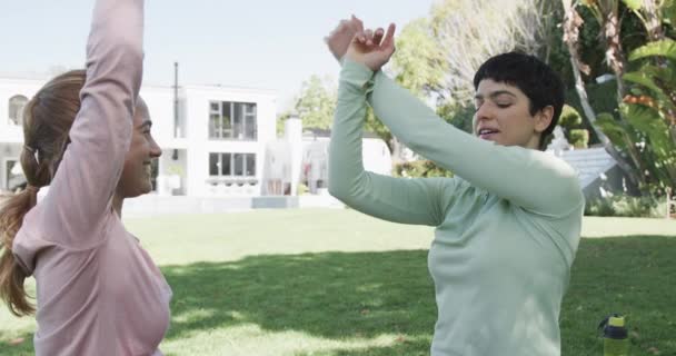 快乐的高加索女同性恋夫妇伸展在阳光灿烂的花园 慢动作 健康和健康的生活方式 — 图库视频影像