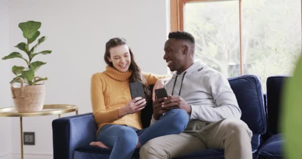 Heureux Couple Diversifié Assis Sur Canapé Utilisant Smartphone Carte Crédit — Video