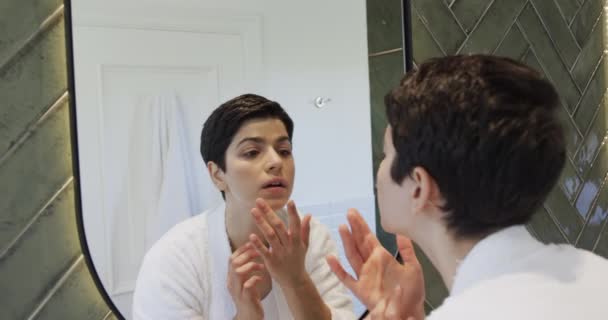 Šťastná Běloška Dívá Zrcadla Dotýká Tváře Vlasů Usmívá Koupelně Krása — Stock video